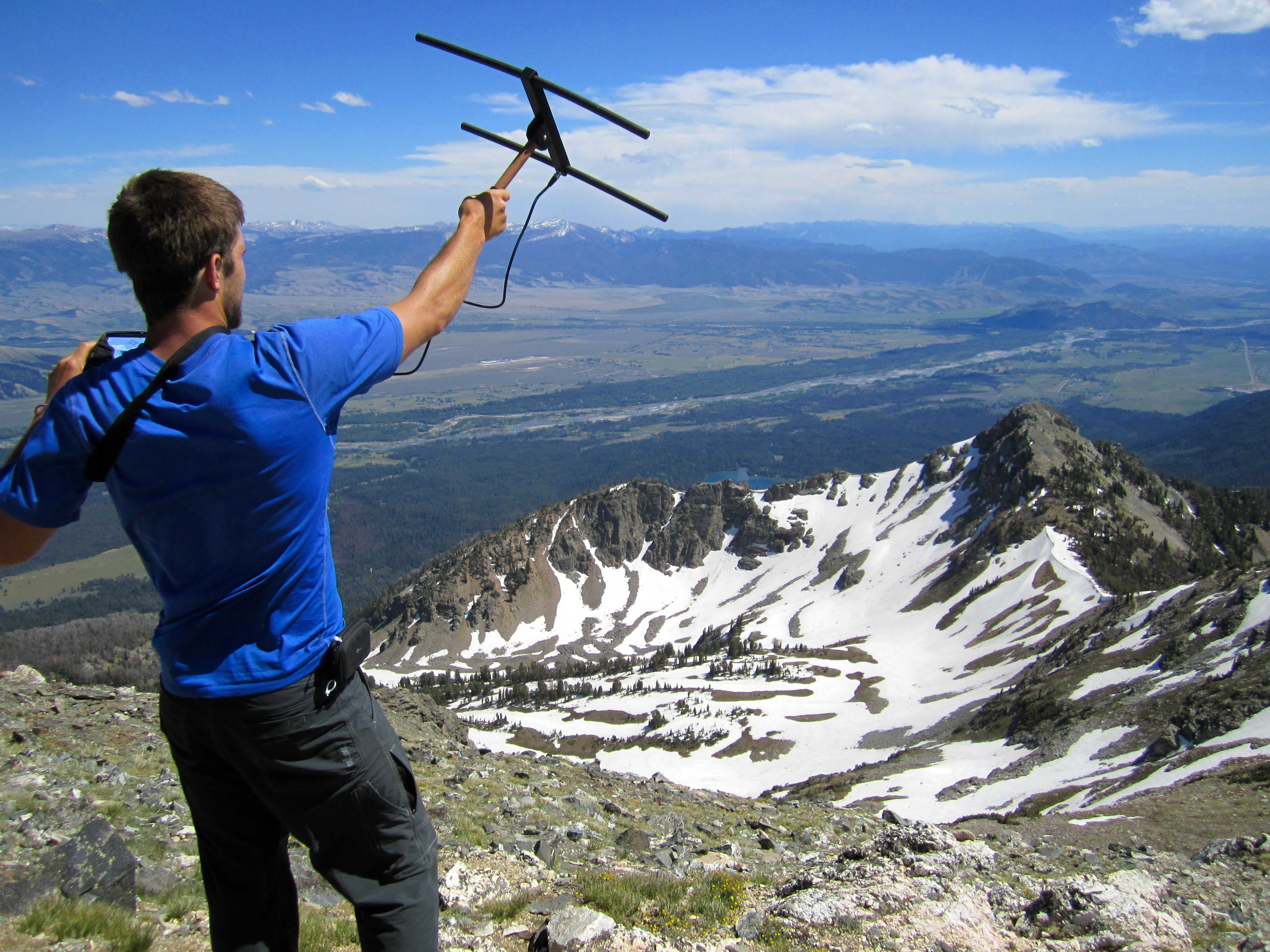 Man holding radio telemetry looking over mountain range