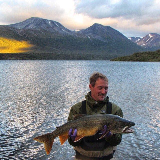 Evan Booher holds a lake trout captured during mercury sampling in Katmai National Park, AK.